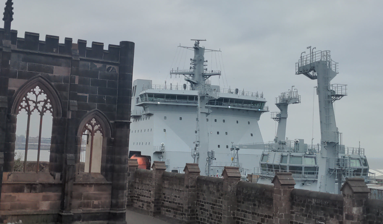 A huge grey ship looming over a wall