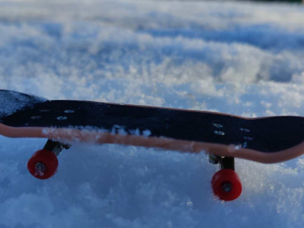 a finger skateboard resting on snow